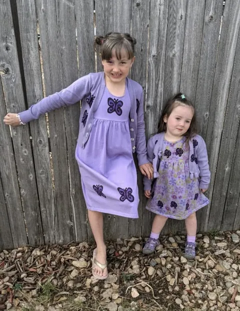 Two sisters in coordinating lavender butterfly outfits